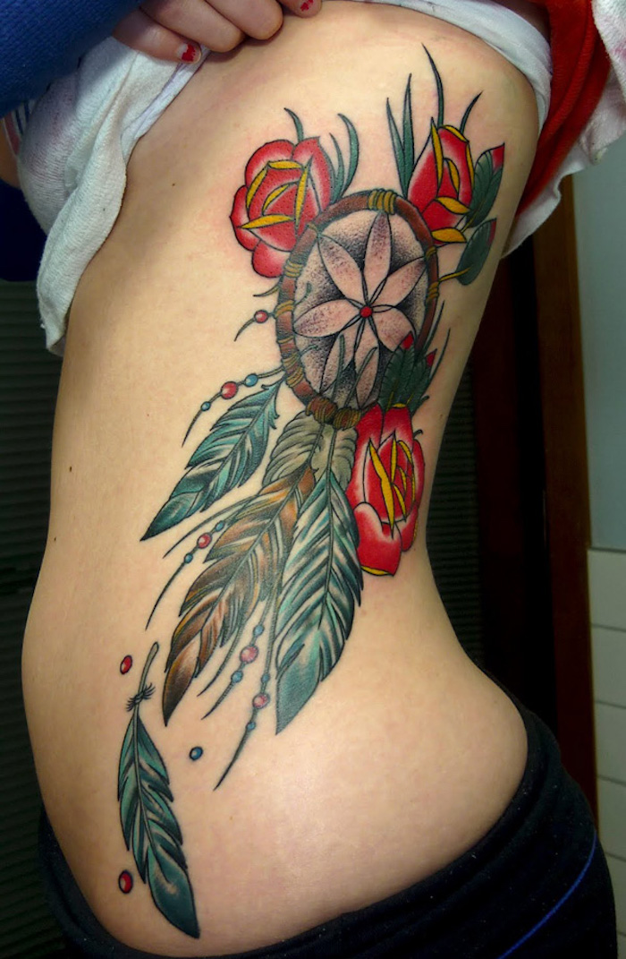 hier ist eine tolle tätowierung für eine frau - ein tattoo mit einem dreamcatcher und drei rosen und grünen tollen blättern
