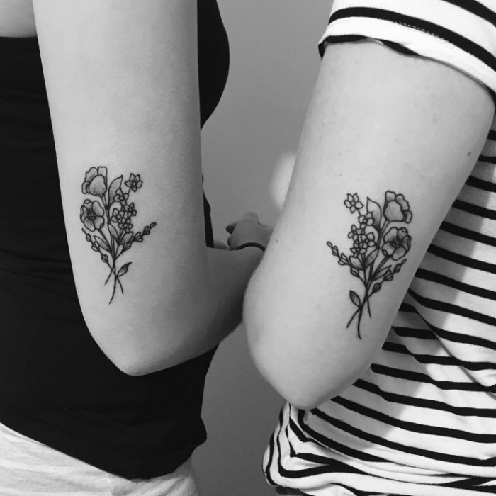 familien tattoo motive für geschwister, tätowierungen mit blumen motiv an den oberarmen, schwarz graues foto