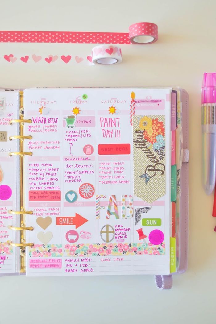 ein rosa Notizbuch mit einer Aufschrift Schönheit mit bunten Kugelschreibern Filofax dekorieren