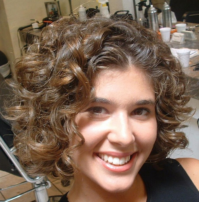 ein Mädchen mit einem schönen Lächeln das Kurzhaarfrisuren für lockiges Haar präsentiert
