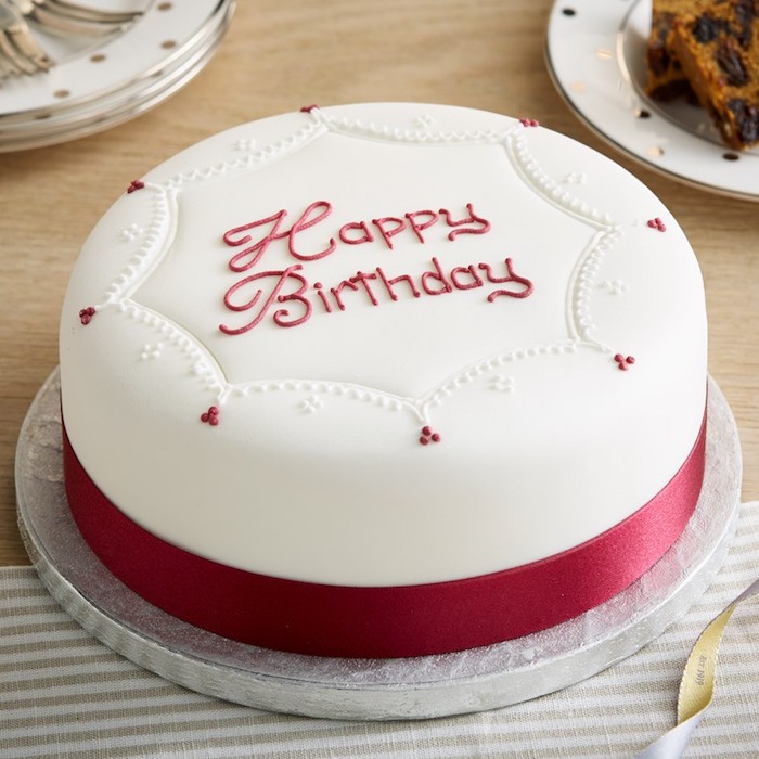 Torte zum Geburtstag, schön dekoriert mit weißem Guss und roten Punkten