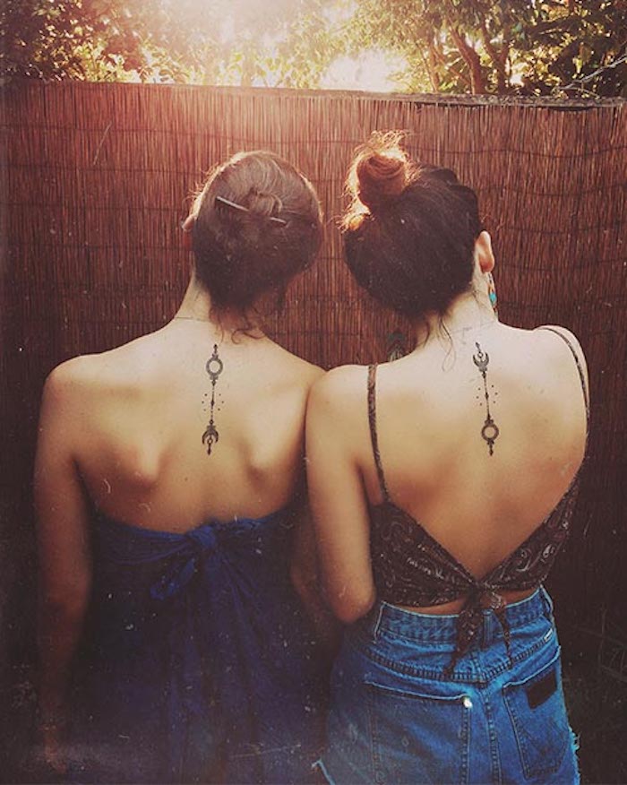 umgedrehtes Symbol an den beiden Frauen Rücken von zwei Schwester - Geschwister Tattoo Motive
