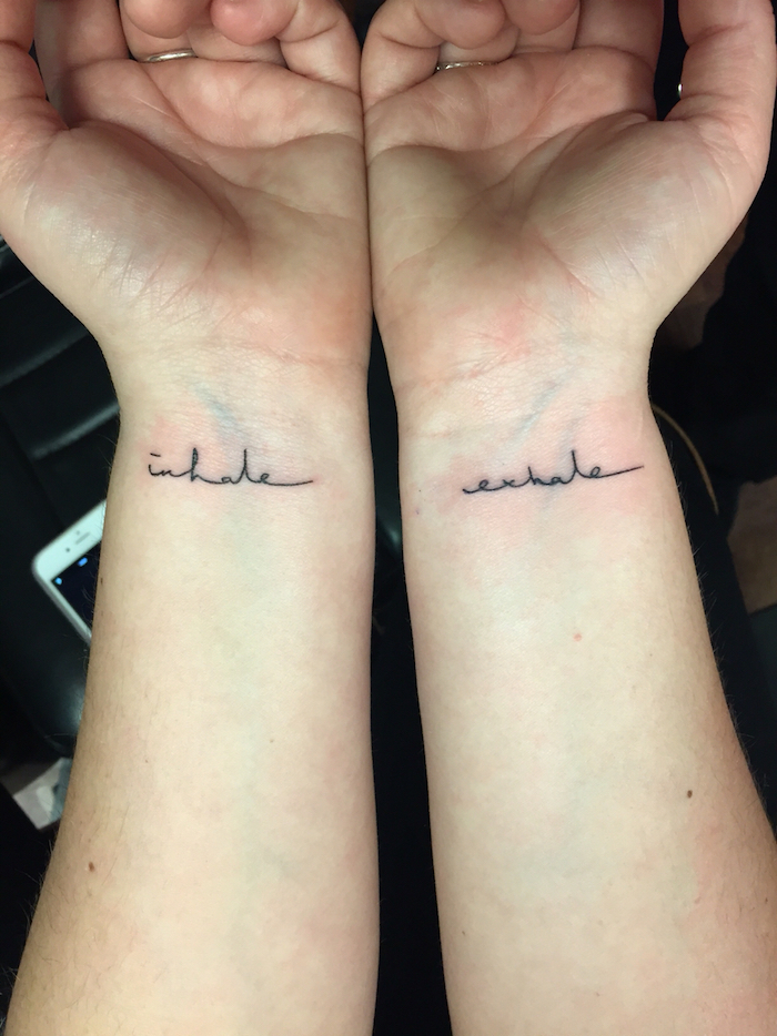 hier finden sie zwei hände mit kleinen schwarzen tattoos auf dem handgelenk - tattoo schriften handgelenk 