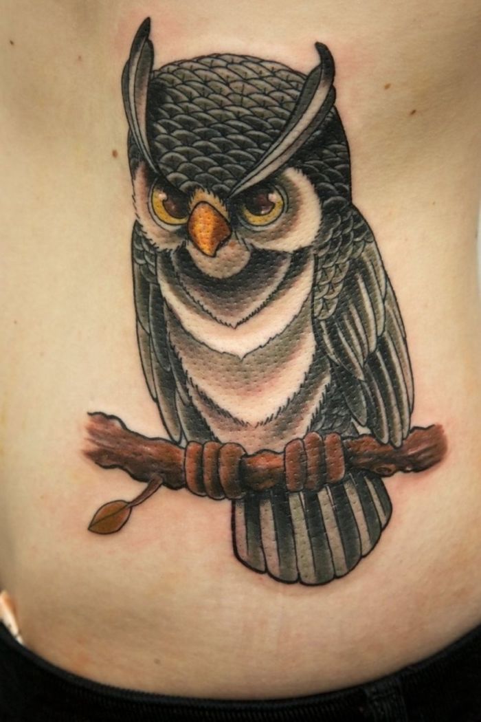 ein schwarzer uhu mit kleinen gelben augen und ein ast - idee zum thema owl tattoo