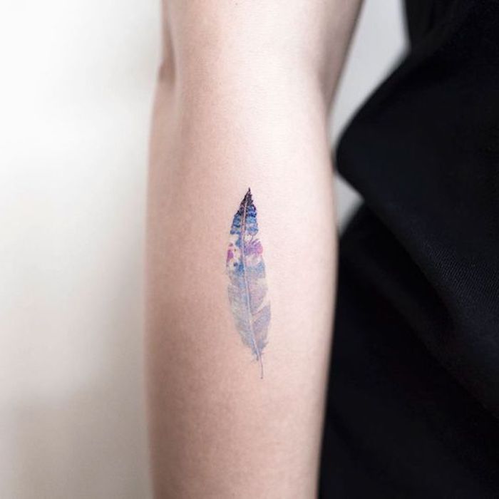 kleines tattoo am unterarm, wasserfarben tattoo mit feder-motiv