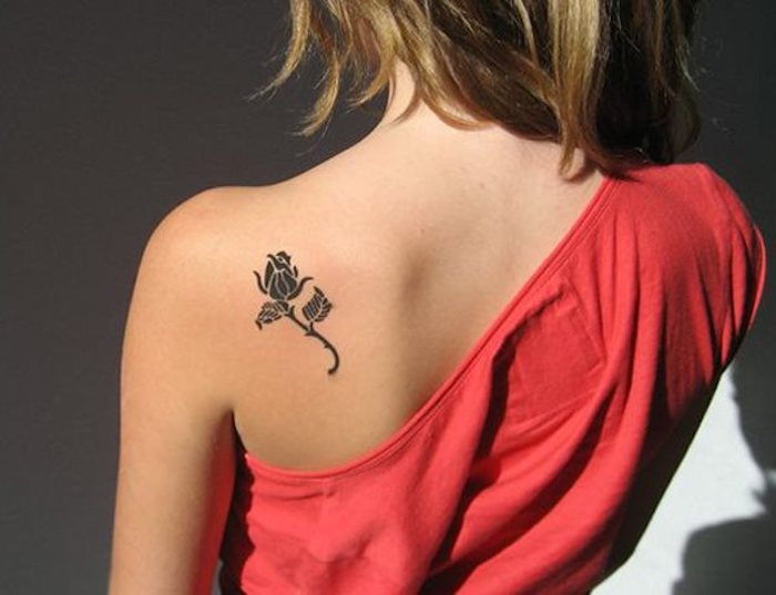 bleiebteste tattoos, frau mit rotem kleid und kleinem rose tattoo