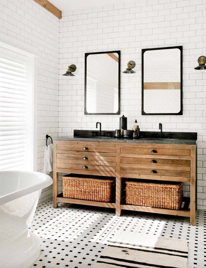 Badezimmer im Landhausstil, weiße Fliesen, zwei große Spiegel, Holzschränke und Rattankörbe