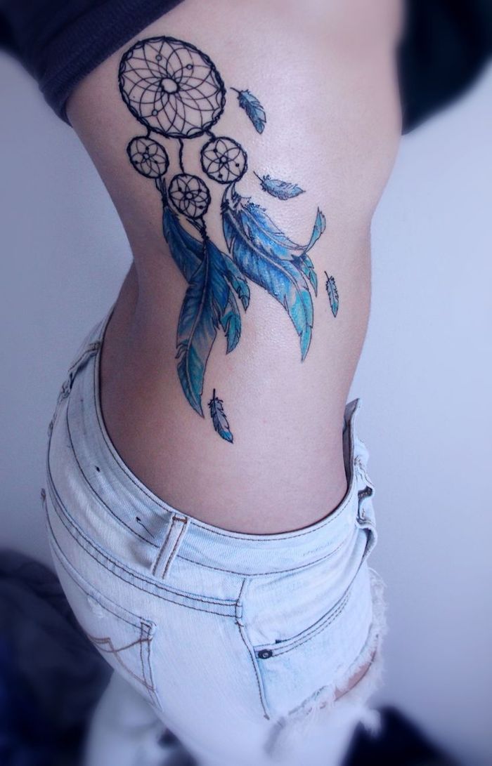 werfen sie einen blick auf diese idee für einen sehr schön aussehenden tattoo mit einem traumfänger mit langen blauen federn - tattoo für eine frau