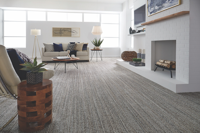 grauer Teppich in Streifen - ein weißes Sofa mit blauen Kissen - günstiger Bodenbelag