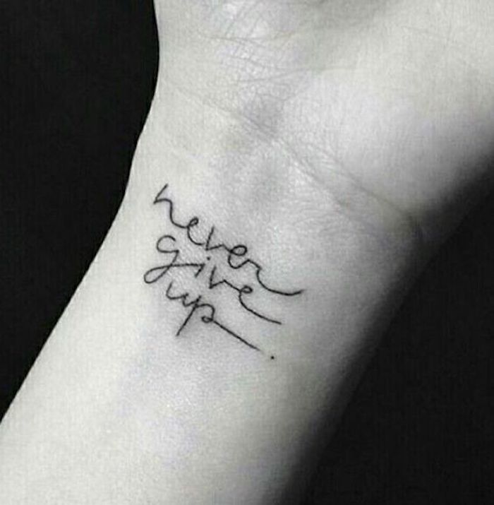 Gebe nie auf steht mit Tattoo Schrift am Handgelenk ein Punkt am Ende des Satzes