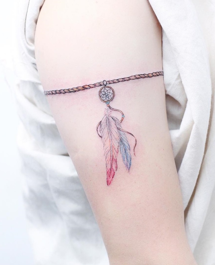 Traumfänger Tattoo mit zwei Federn am Schulter, Armband Tattoo, kleine Tattoos für Frauen 