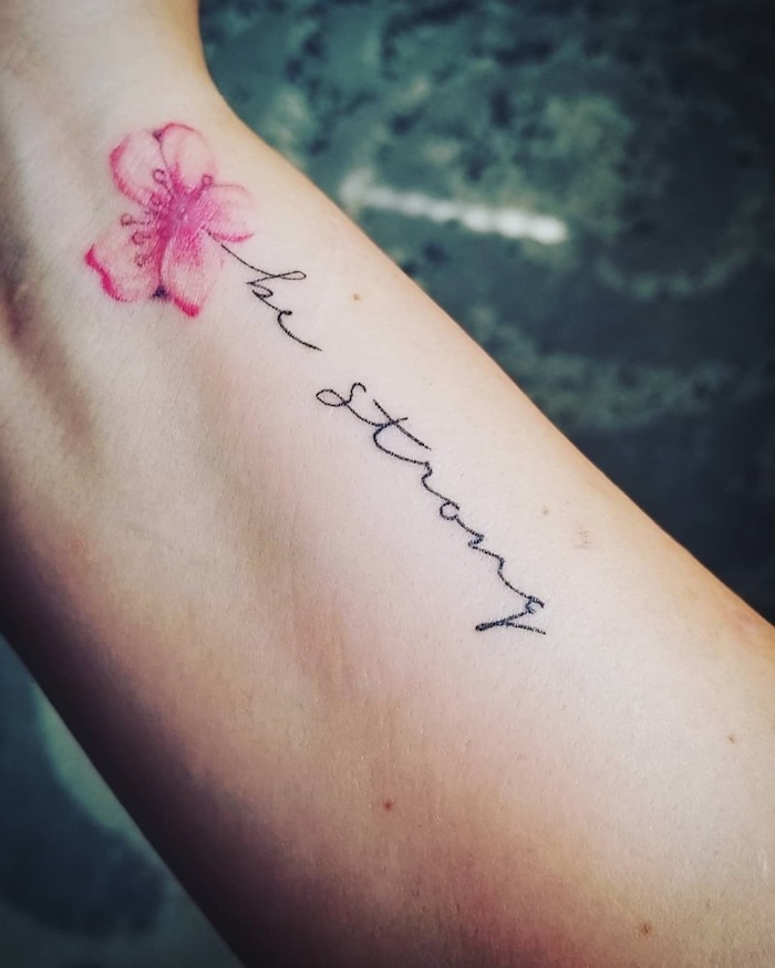 Kleines Tattoo in feiner Schreibschrift und rosafarbene Kirschblüte, Be strong Tattoo, Tattoos für Frauen 