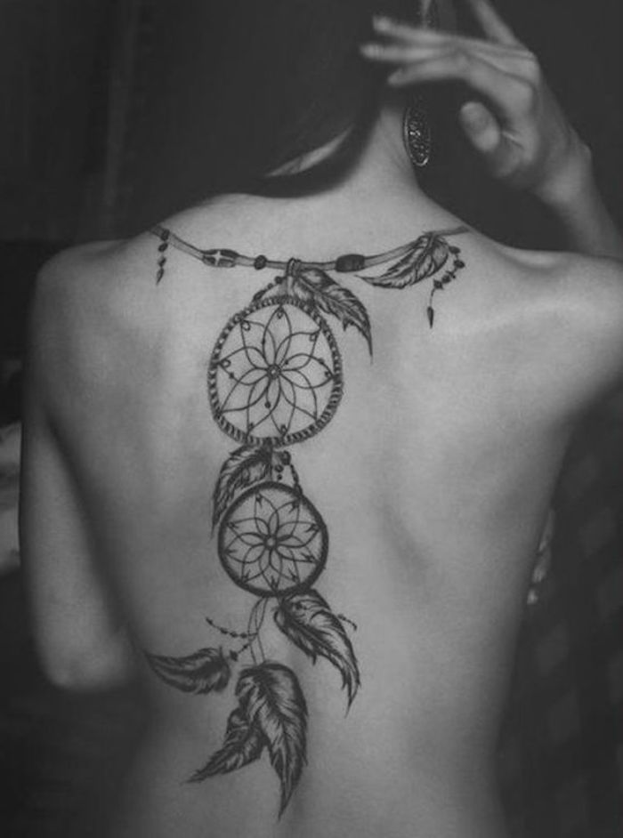 Traumfänger-Tattoo auf dem Rücken eine Frau mit großen Ohrringen
