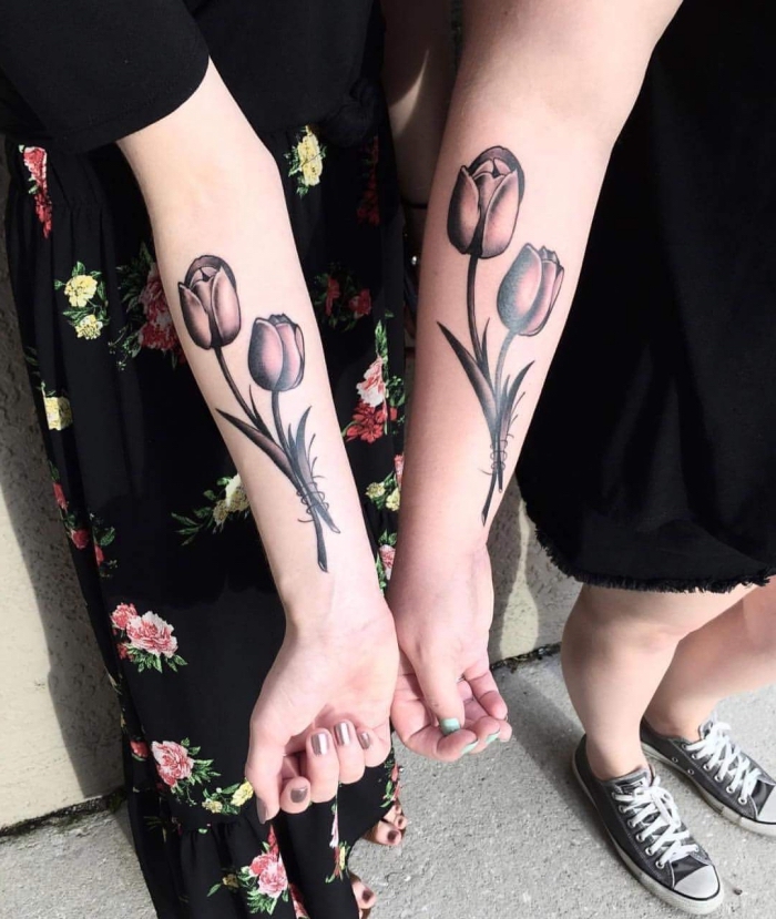 tattoos mit bedeutung, schwester mit großen blackwork tätowierungen an den unterarmen, tulpen und schwarz grau