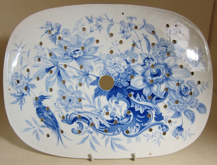 ein ovales Teller aus weißen Keramik mit abstrakten Malereien in blau