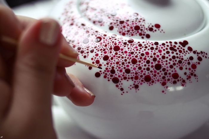 eine kleine Teekanne in weißer Farbe mit kleinen und großen roten Punkten