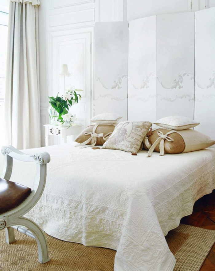 Vintage Schlafzimmer in Weiß, viele Deko Kissen, Vase mit Blumen, Nachttischlampe