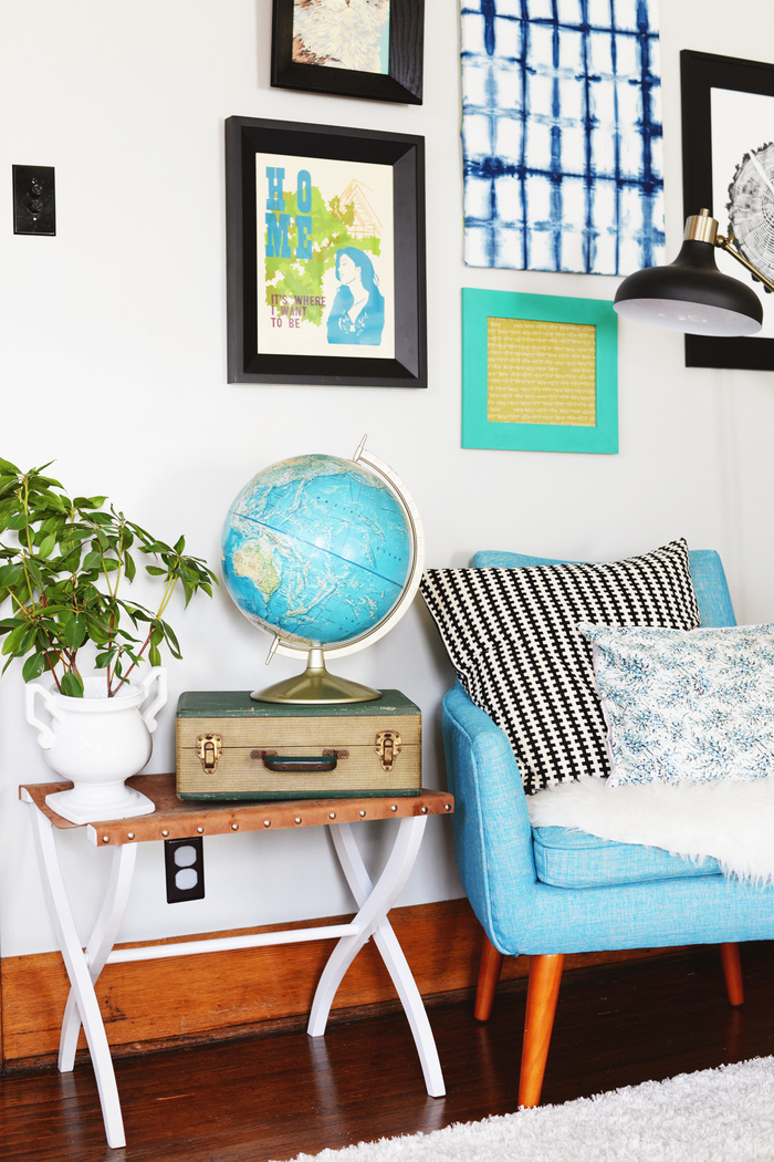 Vintage Einrichtung fürs Wohnzimmer, blauer Sessel mit Deko Kissen, Zimmerpflanze, Globus und Koffer