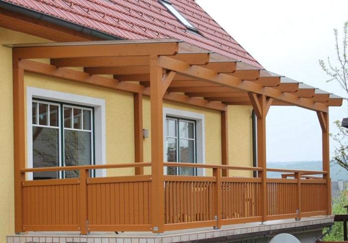 Terrassenüberdachung Holz braun Lasuren Balkon Idee gelbe Fassade