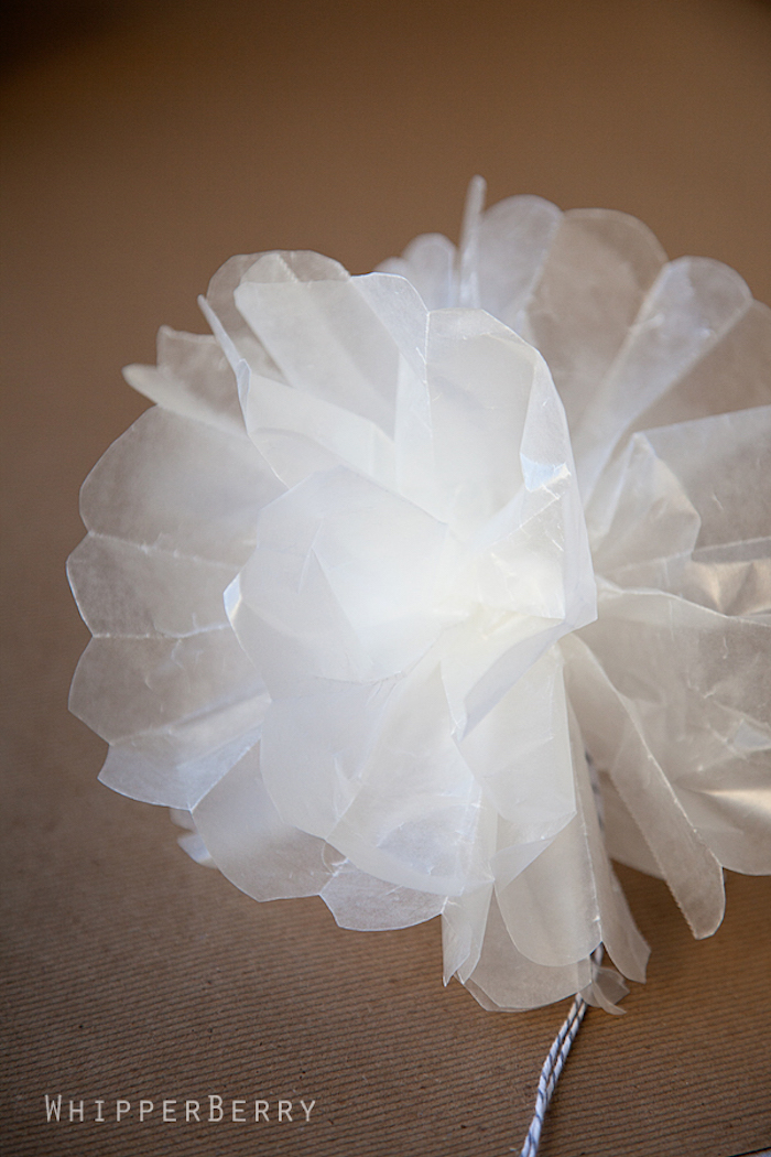 weiße Blume aus leicht durchsichtigem Papier, gebunden mit einem Faden