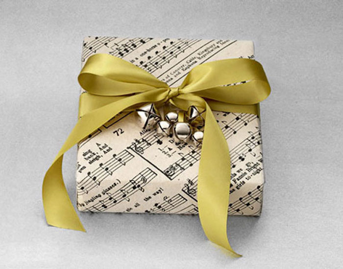 kleines Geschenk, eingepackt in Papier mit Musiknoten, Glockendeko
