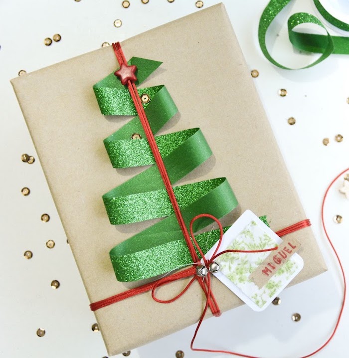Weihnachtsgeschenk verpacken und mit einer grünen Schleife mit rotem Stern verzieren