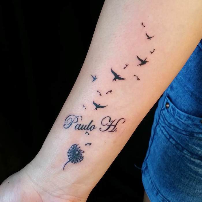 tattoos mit bedeutung, schwarze tätowierung mit blume und vögeln am arm