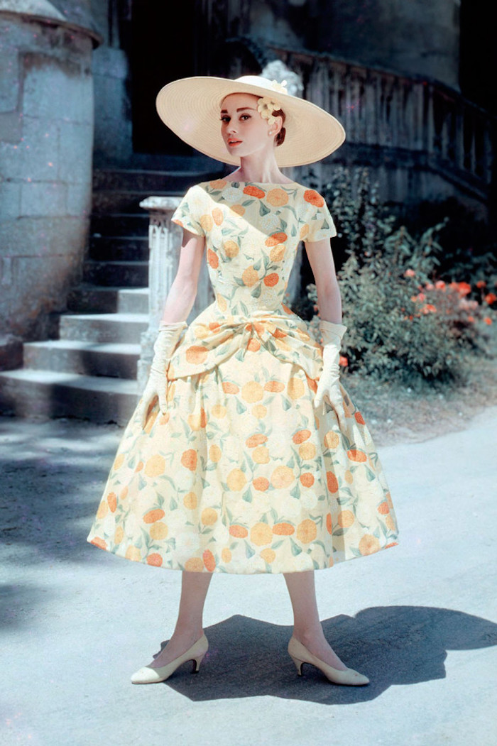 Audrey Hepburn in einem langen Kleid mit Blumenmotiven, Steintreppen, Blumenbeet