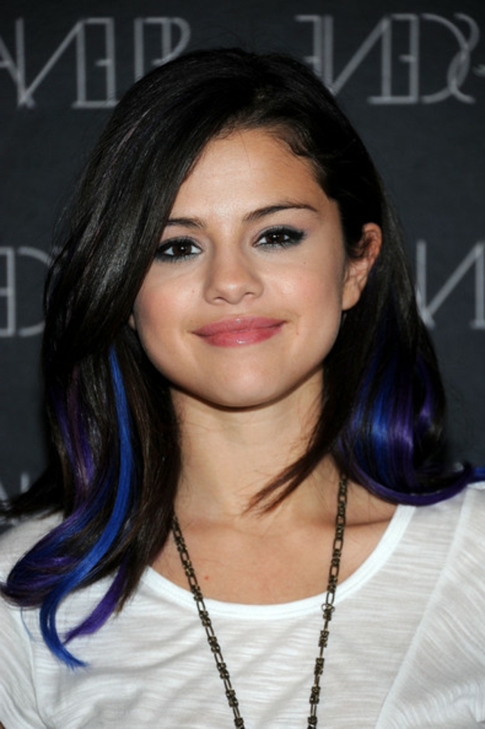 Selena Gomez, schwarze Haare mit dunkelblauen Strähnen, natürlicher Make-up, weiße Bluse, lange Kette