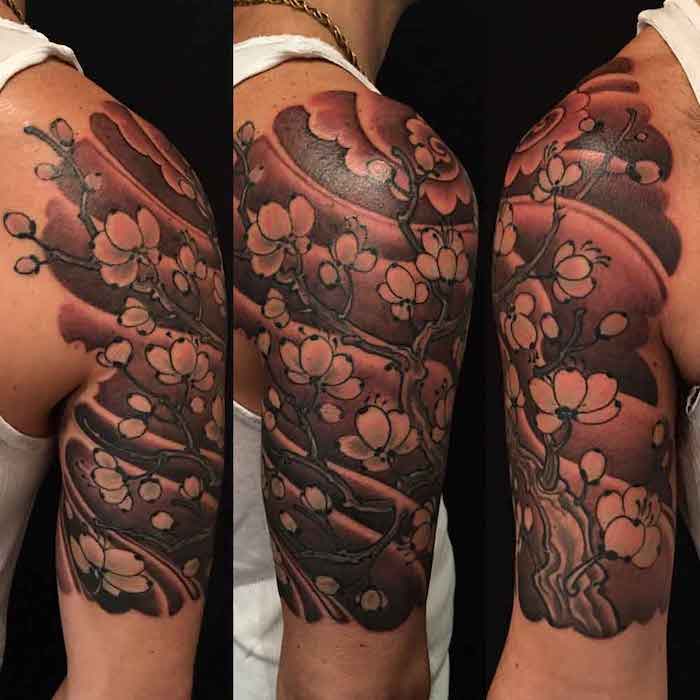 chinesische tattoos am oberarm, große tätowierung mit pfamenblütten-motiv