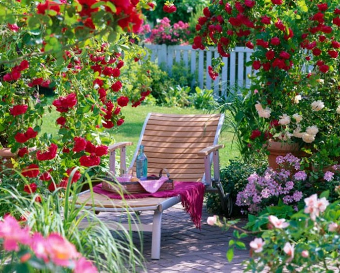 gartengestaltung kleine gärten, chaiselongue aus holz, viele bunte blumen
