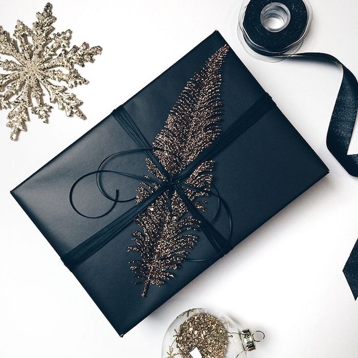 elegante Geschenkverpackung in schwarzer Farbe, Federdeko, Weihnachtskugel