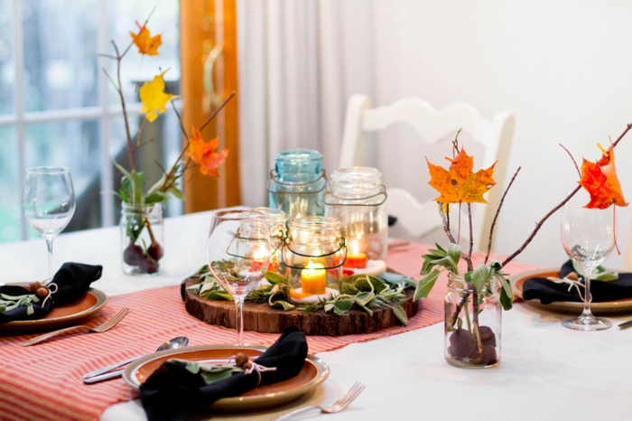 den Tisch herbstlich arrangieren, Herbstblätter und Kastanien in Einmachgläsern, kleine Laternen 