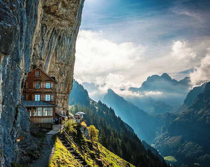 Berghaus mit atemberaubender Aussicht, spitze Berge, Sonnenstrahlen