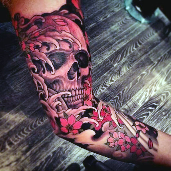 traditional tattoo am arm, tätowierung mit schädel-motiv und kirschenblüten
