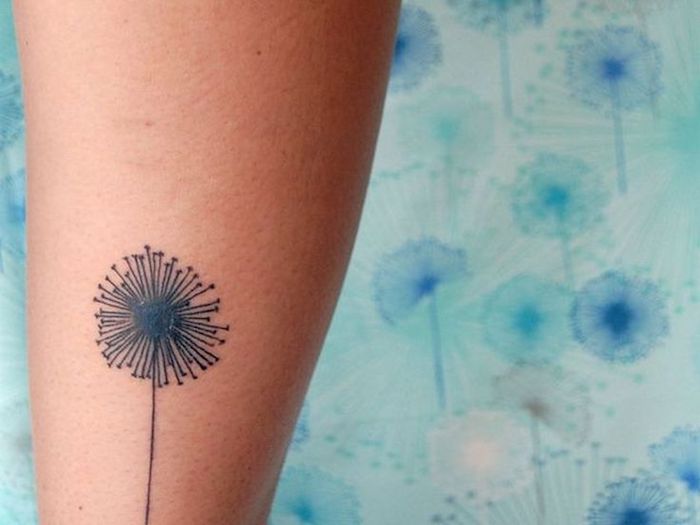 kleine tattoos frauen, schwarze pusteblume am bein, blumen tattoo