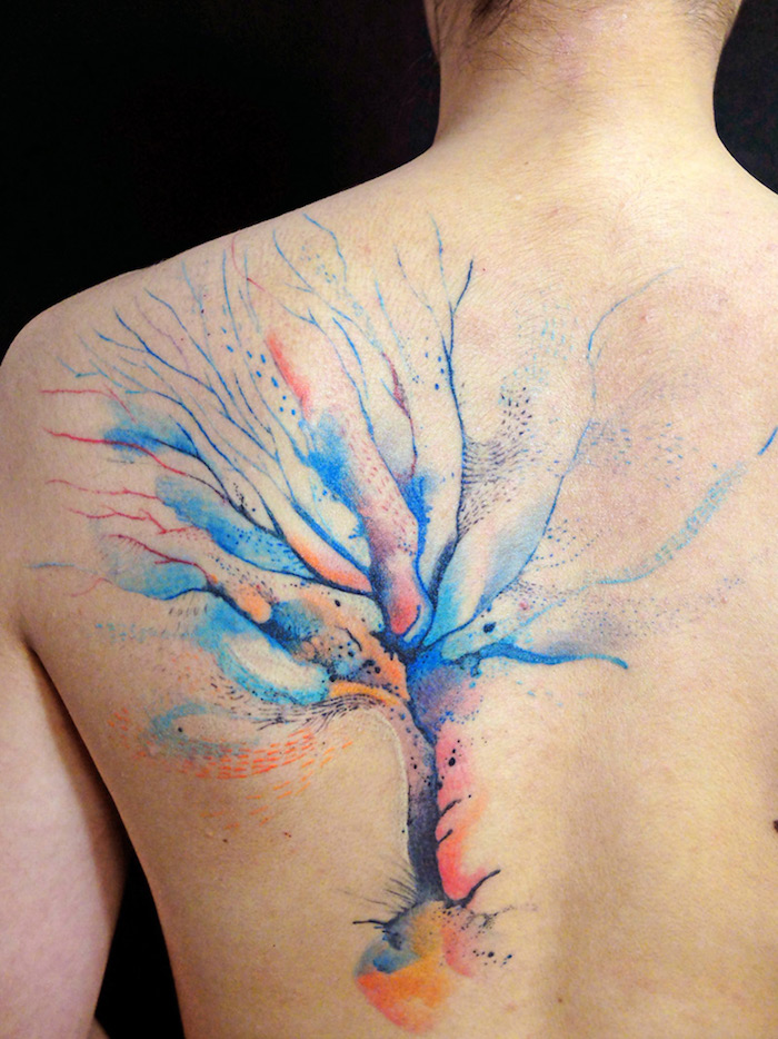 ein Wasserfarbe Tattoo Lebensbaum in blau, gelb und rot am Rücken