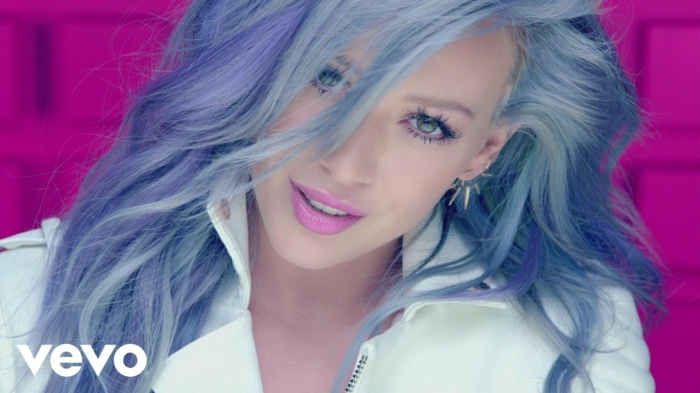 Hilary Duff mit lila Haaren, violette Lippen, natürlicher Augen-Make-up, weißer Outfit