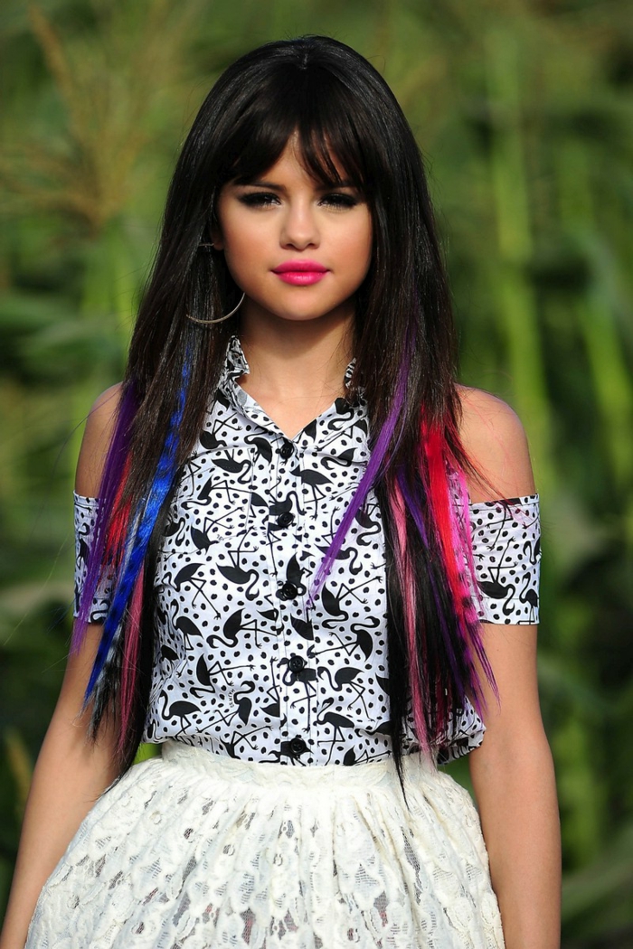 Selena Gomez mit bunten Strähnen, langes Haar mit Pony, greller Lippenstift, schwarze Mascara