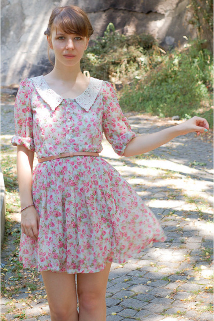 junges Mädchen mit kurzem rosa Kleid aus Tüll, braunem Ledergürtel, Spaziergang