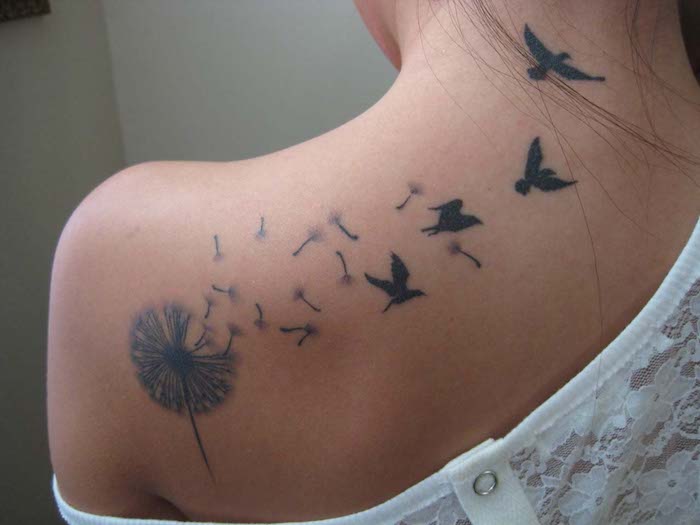 tattoo auf der schulter, pusteblume mit fliegenden samen am rücken