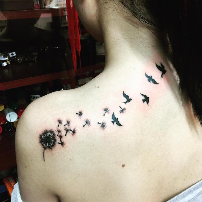 tattoo vogel, frau mit schwarzer tätowierung am rücken