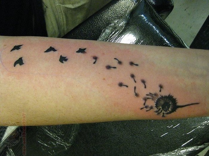 tattoo vogel, tätowierung mit pusteblume mit fliegenen samen am arm