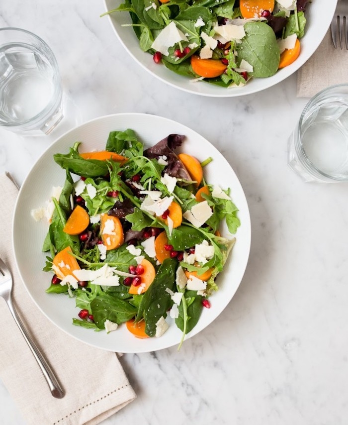 kaki vitamine, gesunder salat mit weißem käse, gemischten salatblättern und persimonen