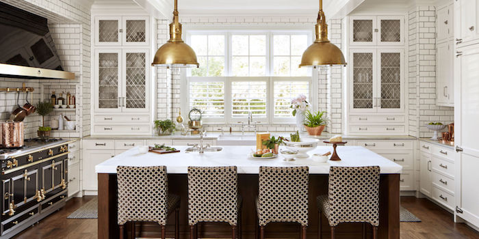 eine Luxus Wohnküche mit zwei Lampen in goldenen Farben, weiße Arbeitsplatte