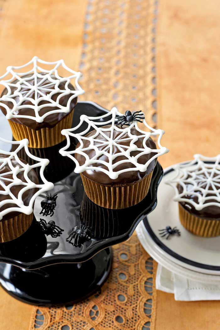 halloween gebäck dekoriert mit spinnweben aus weißer schokolade