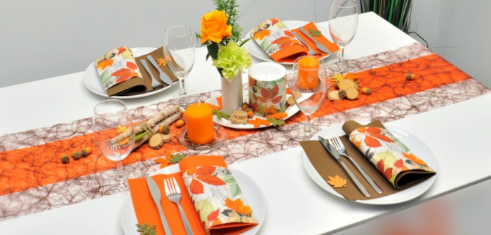 Herbstliche Tischdekoration, warme Farben, natürliche Deko-Elemente, Eicheln, Blumen und Herbstblätter