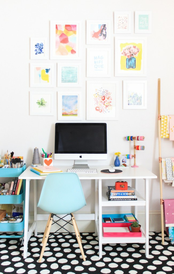 Arbeitszimmer Einrichtung, viele Gemälden an der Wand, schwarzer Teppich mit weißen Punkten, weißer Schreibtisch und blauer Stuhl