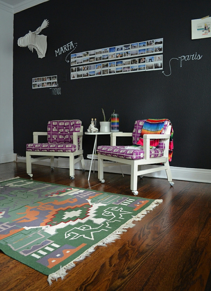 Arbeitszimmer Einrichtung, weiße Holzstühle mit lila Kissen, bunter Teppich, Wand mit Tafelfarbe, Fotos an der Wand