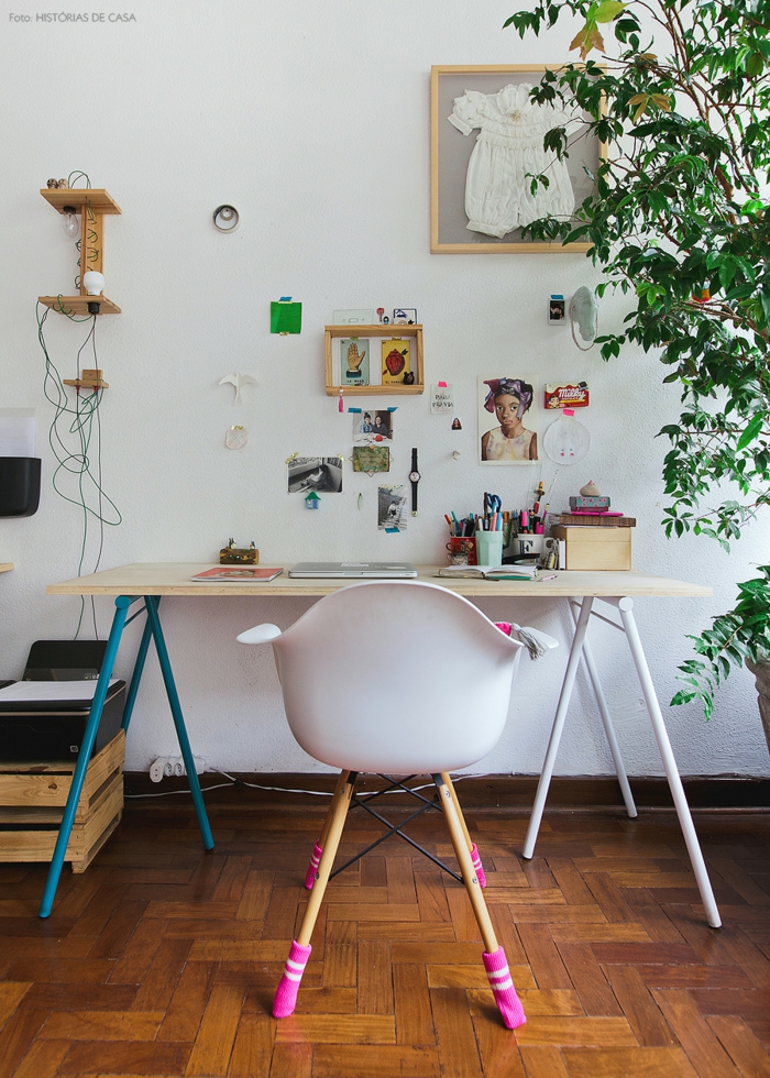 Arbeitszimmer in Vintage Stil, Schreibtisch aus Holz, Stuhl mit rosafarbenen Strümpfen, Fotos, Notizen und Babykleidung an der Wand
